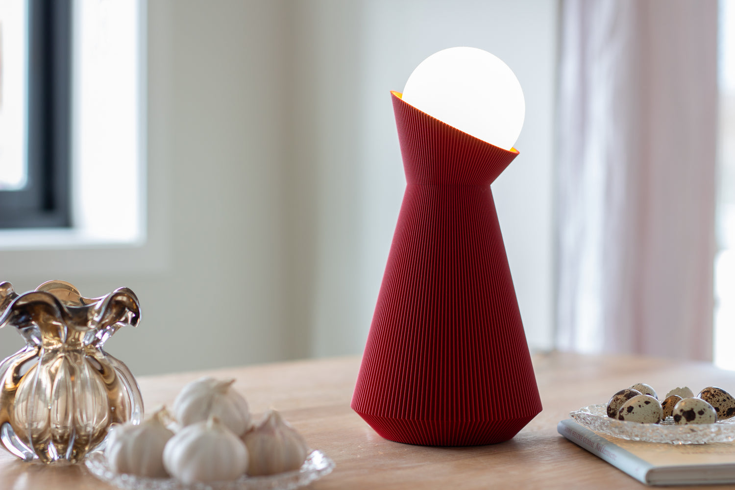 Red lamp with a white bulb on a wooden surface