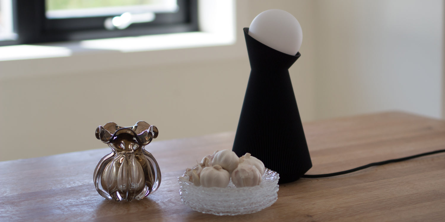 Charcoal sera lamp with a white light bulb on a wooden table 