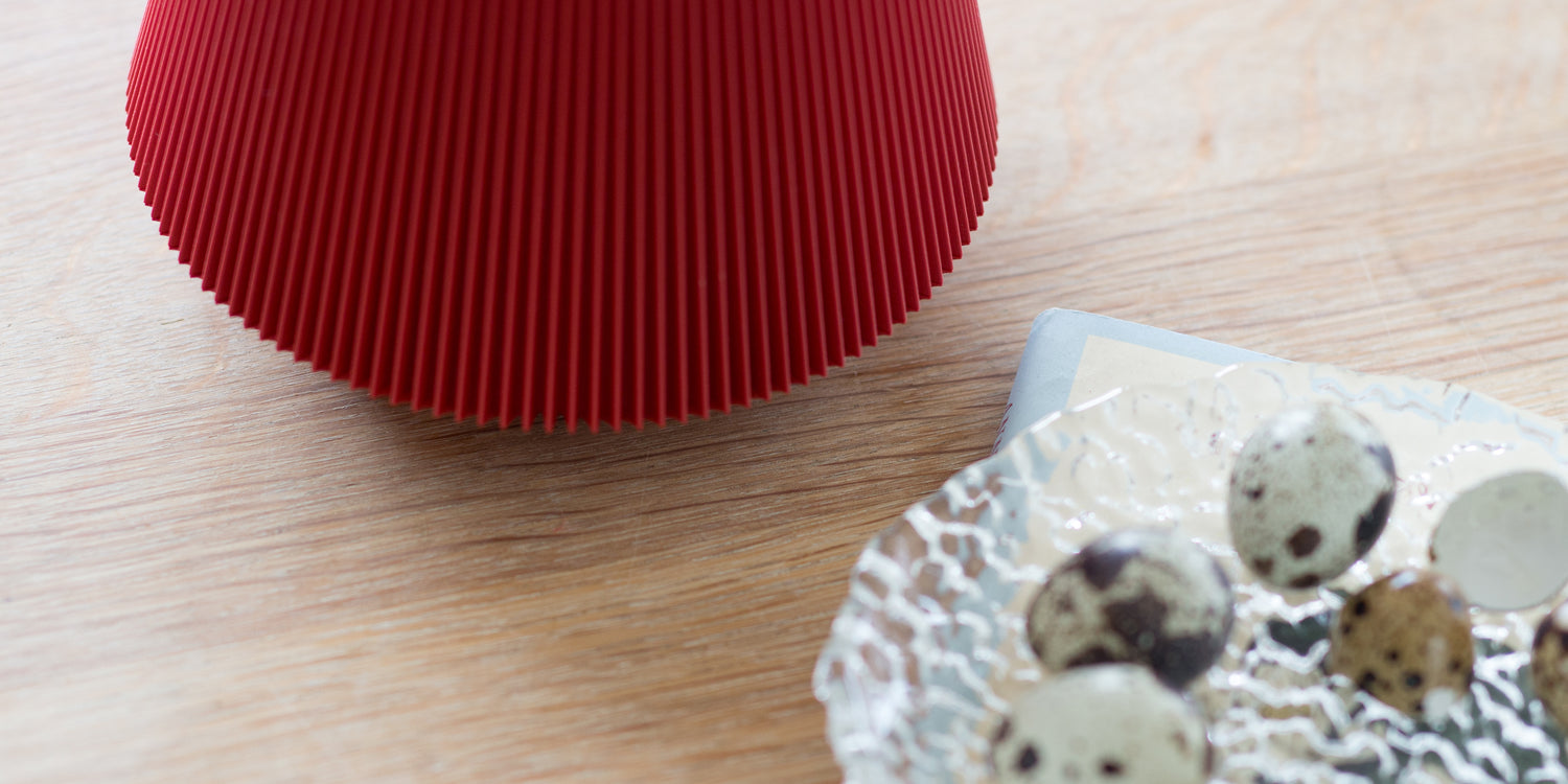 Deep Red sera lamp on a wooden surface with a small dish of quail eggs.