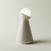Bone white sera table lamp with white dekorative light bulb on a light gray background