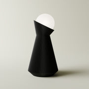 Charcoal sera table lamp with white dekorative light bulb on a light gray background