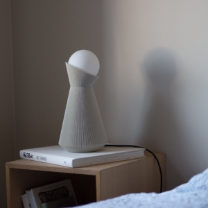 Bone white Sera table lamp with the bulb lit