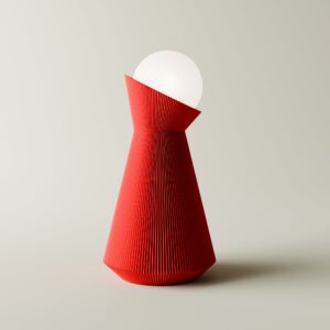 Deep red Sera table lamp with a white decorative bulb on a light grey background
