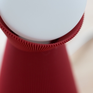 Close-up of the deep red Sera lamp shade with a white bulb
