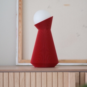 Deep red Sera lamp on a wooden surface in front of a light grey wall