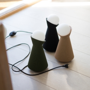 Forest green Sera table lamp with the bulb lit